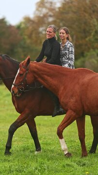 Two women riding bareback on a horse in rural New Zealand