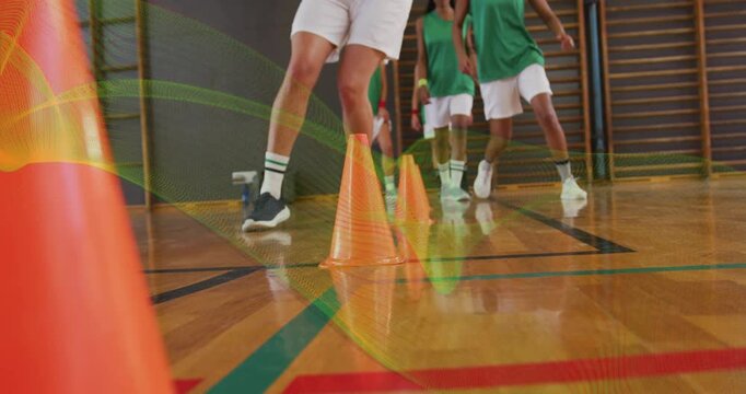 Lead athlete grabbing basketball, dribbling through cones team following relay training for agility