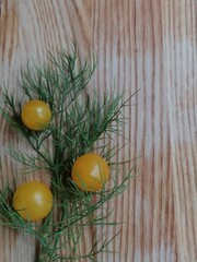 fresh dill and yellow cherry tomatoes on wooden board 