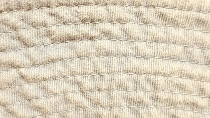 soft quilted beige fleece fabric with stitched arc pattern closeup for textile design or cozy...