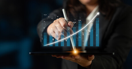A business professional interacts with a tablet using a digital pen, showcasing vibrant graphs and...