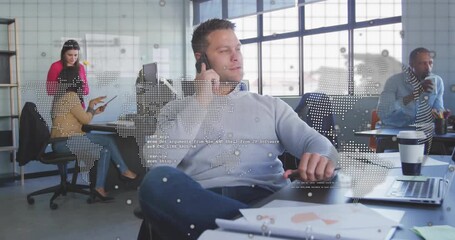 Mid-adult man answering smartphone call and world map overlay pulsing data while team using tablet - Powered by Adobe