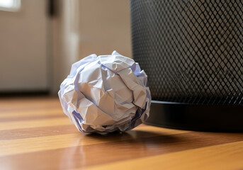 Crumpled Paper Ball Next to an Empty Trash Bin in the Corner, empty trash bin in corner