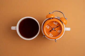 Coffee and clock on a colored background.  Time to drink coffee. Break time. Creative idea.