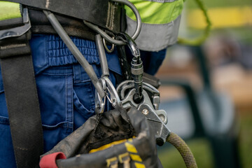 Safety harness with carabiners and rope lanyard used by utility worker for fall protection and...