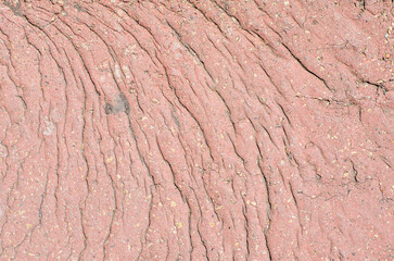 Closeup of dry clay soil texture with parallel cracks and small natural inclusions background