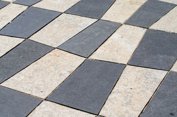Closeup of tile surface with alternating light and dark diamond shapes arranged in checkerboard...