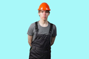 A young man wearing an orange construction helmet. Isolate.