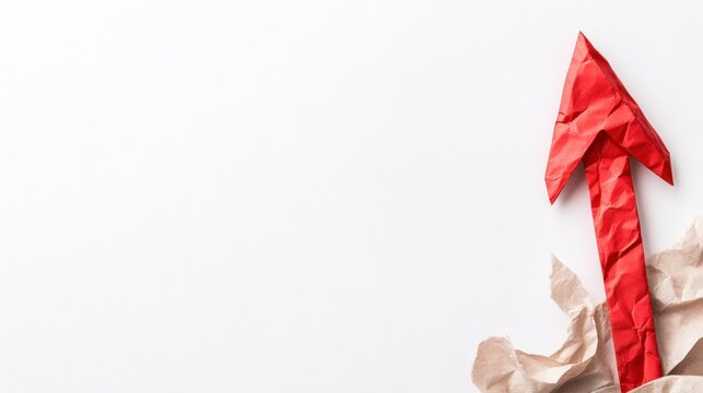 Red crumpled paper arrow breaking through torn brown paper on a white background symbolizing business growth upward trend progress success and achievement