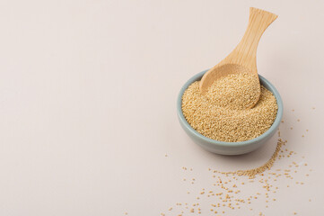 Whole amaranth grains in a bowl on a light background. Healthy food, eco