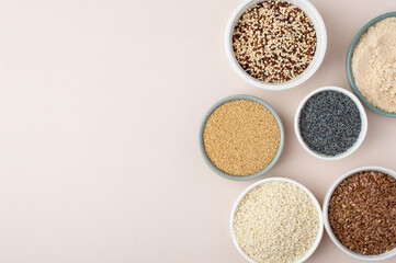 Assortment of superfoods, seeds, grains in bowls on light background. Amaranth, sesame, flaxseed, poppy, quinoa. Top view