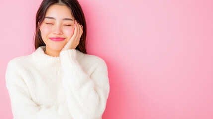 Content and relaxed young Asian woman with gentle smile and closed eyes, dressed in warm white turtleneck, posing on bright pink background