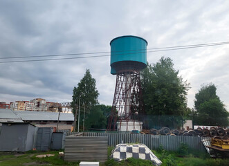 A blue water tower against a gloomy sky.