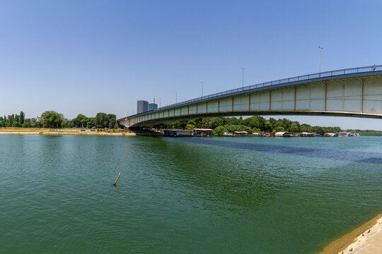 Brankov Bridge spanning the turquoise Sava River on a summer day &ndash; a vital link between Belgrade&rsquo;s city center and New Belgrade under vibrant blue skies.