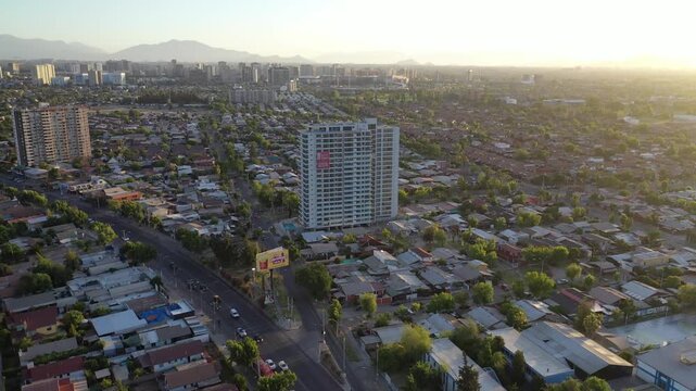 Atardecer dorado sobre los edificios de Macul, con sombras largas y cielo c&aacute;lido en Santiago de Chile