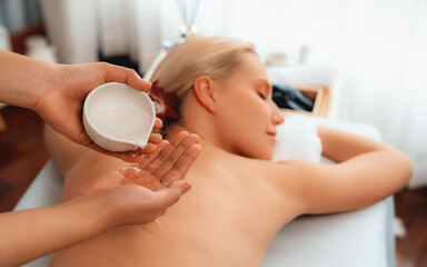 Masseur hands pouring aroma oil on woman back. Masseuse prepare oil massage procedure for customer...