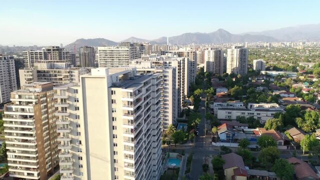 Atardecer dorado sobre los edificios de Macul, con sombras largas y cielo c&aacute;lido en Santiago de Chile