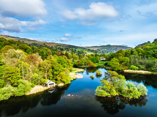 Obraz premium Farms and Mountains over road A591 from a drone, Grasmere Lake, Grasmere, Ambleside, Lake District, Westmorland, Cumbria, UK