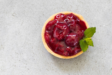Cherry tartlet. With custard. Light gray background. Top view