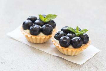 Two round Blueberry tartlets. Light background. Close up