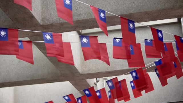 Slow motion of multiple Taiwan flags arranged under a concrete roof, showcasing patriotism and national pride in an organized urban setting.