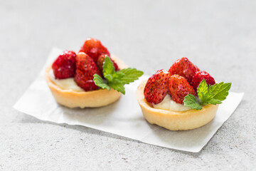 Two Round Strawberry tartlets. Light gray background. Close up