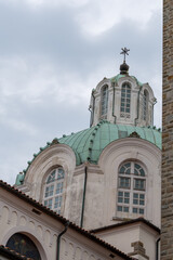 Obraz premium The green copper dome and arched windows of the Marian Sanctuary on Barbana Island, standing tall against a moody sky near Grado, Italy.