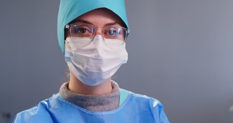 Female physician, surgeon doctor, serious woman nurse medical professional looking, wearing face mask, cape in clinic or hospital, skilled focused on healthcare and job dedication to practice medicine - Powered by Adobe
