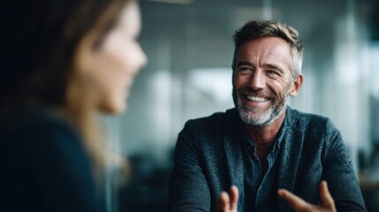 A smiling businessman in a meeting, possibly during a work discussion or a friendly conversation.