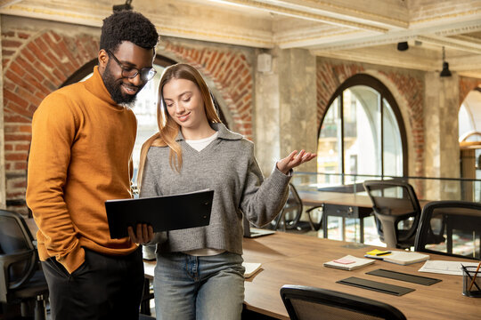 Multiethnic team members collaborating and smiling while working on business project