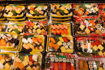 Colorful sushi assortment displayed in plastic containers showcasing various types and styles of sushi