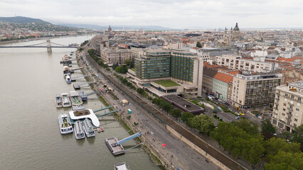 Obraz premium Aerial photo of Budapest, Hungary above the Danube including bridges and ships next to a busy street