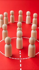 Obraz premium Wooden figures arranged in a circle on a red background, symbolizing teamwork and community
