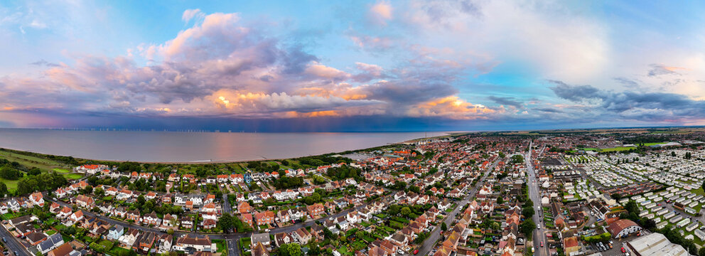 Coastal panorama of the town of Skegness on the Lincolnshire coast with looming storm clouds over the North Sea. Seaside scene with rooftops at sunset.