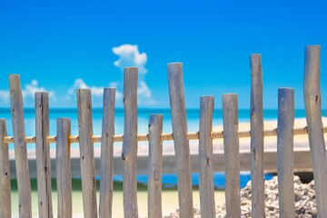 A  weathered wood fence blocking pff two beaches.