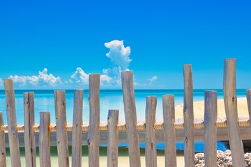 A  weathered wood fence blocking pff two beaches.