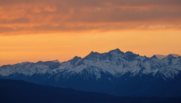 Majestic sunrise illuminates Garibaldi Mountain Range, featuring Mt. Currie peak. View from Whistler RV Park plateau, British Columbia, Canada snow-capped mountains against vibrant orange sky.