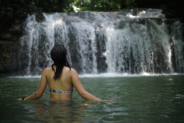 Fototapeta premium Female tourists exploring Siete Altares, which is a natural attraction located near Livingston, Guatemala, featuring seven freshwater pools and waterfalls set within a lush rainforest.