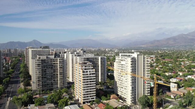 Vista urbana con gr&uacute;as y edificios, recibiendo la &uacute;ltima luz del d&iacute;a en Macul, Santiago de Chile