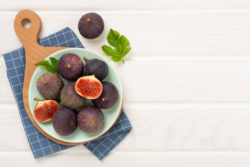 Fresh tasty fig fruits on wooden background, top view