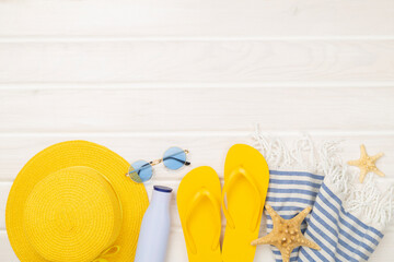 Blue beach accessories on wooden background, top view. Copy space for text