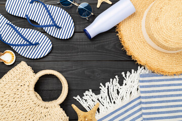 Blue beach accessories on wooden background, top view. Copy space for text