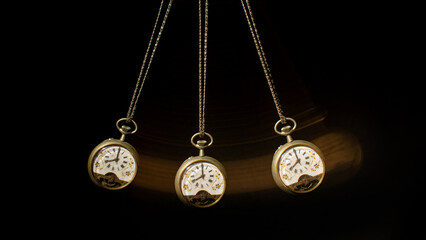 Antique pocket watch moving on a pendulum creating the illusion of multiple clocks, black background, selective focus.