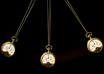 Antique pocket watch moving on a pendulum creating the illusion of multiple clocks, black...
