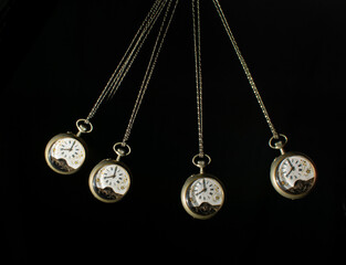 Antique pocket watch moving on a pendulum creating the illusion of multiple clocks, black...