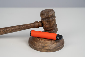 Judge's gavel and e-cigarette. Smoking ban. Tobacco heating systems. 