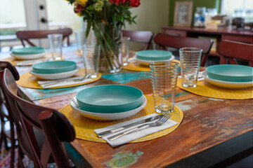 Close-up of a set dining table with bowls, plates, drinking glasses, and silverware