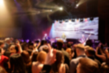 Blurred background rock concert with light background, concert in hall at night. people enjoying...