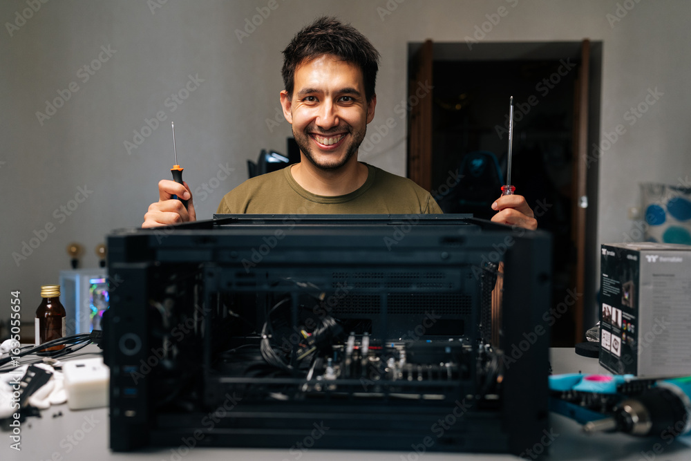 Poster friendly computer technician working with screwdrivers during desktop computer assembly, demonstrati