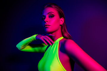 Glamorous young woman in vibrant neon lighting, showcasing bold fashion, beauty, and contemporary...